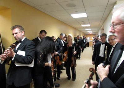 A group of people from the SoCal Philharmonic standing in a hallway.