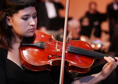 A woman playing a violin with the SoCal Philharmonic.