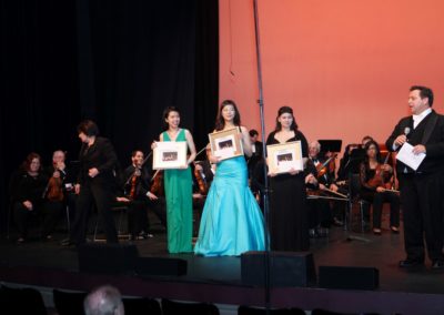 A group of people standing on stage holding trophies at the SoCal Philharmonic.