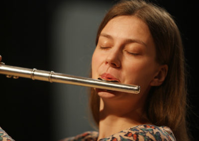 A woman playing a flute for the SoCal Philharmonic.